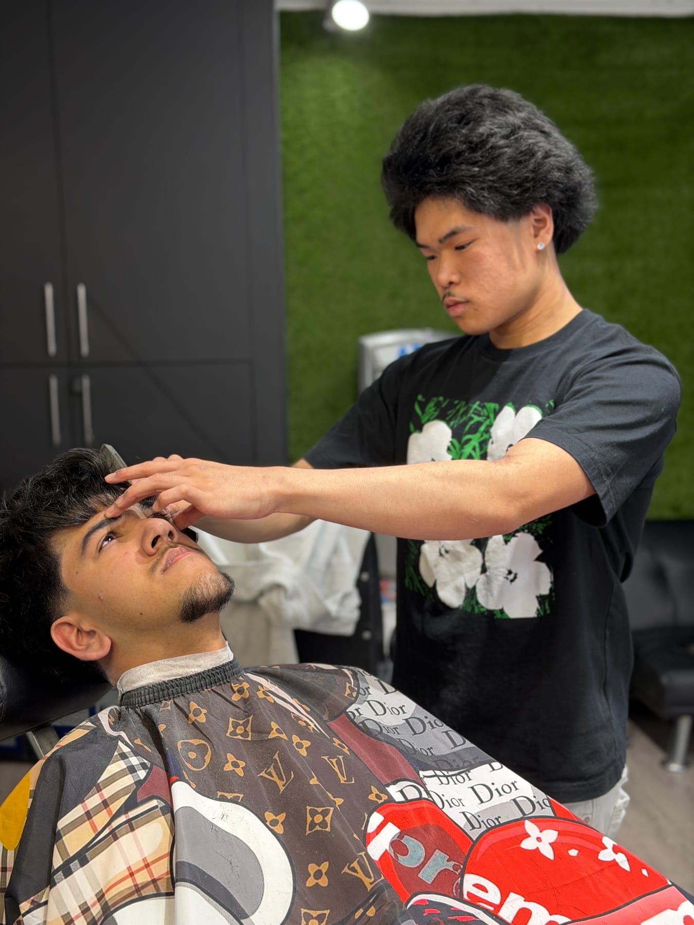 KC cutting a client's hair at KHUTTZZ