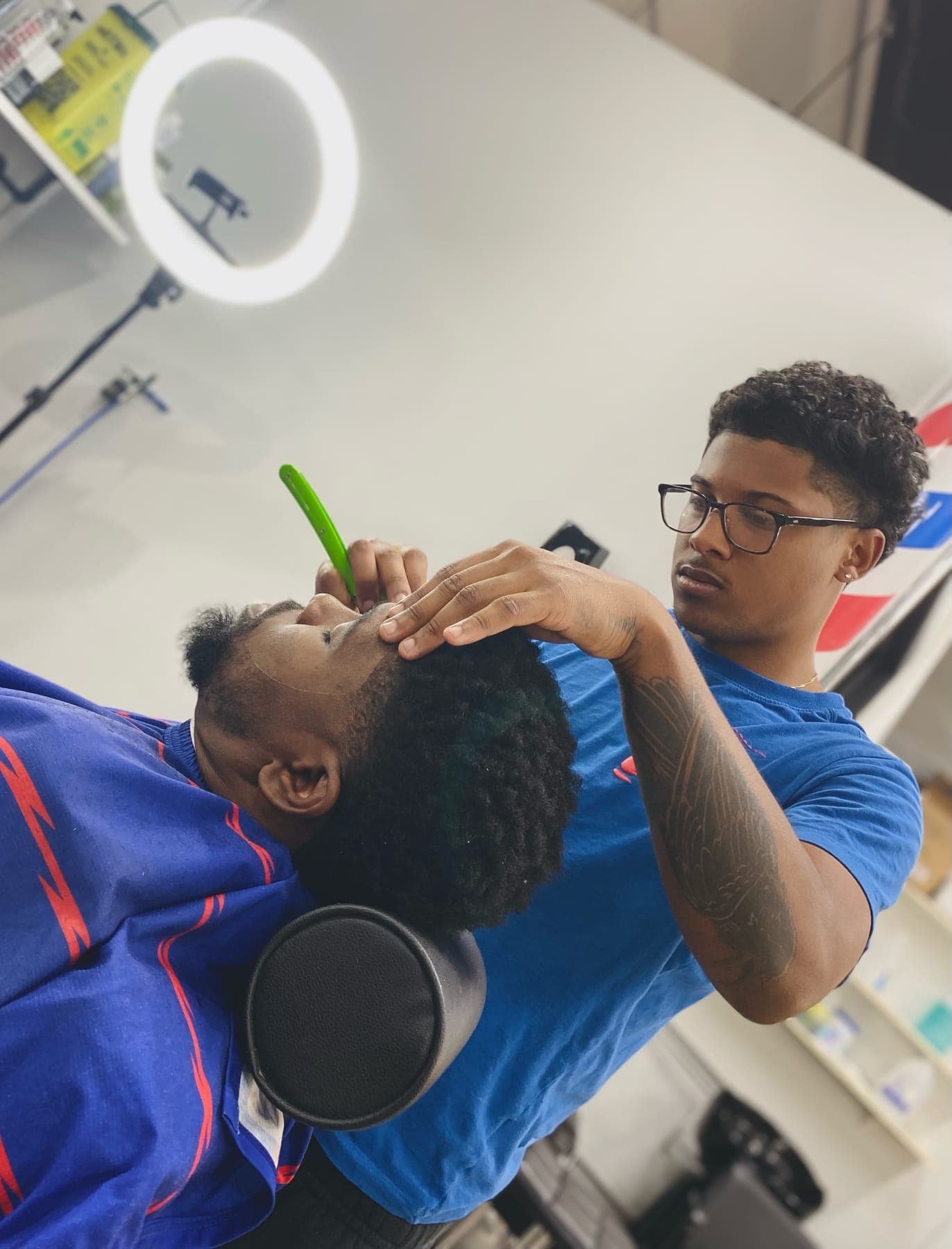 Khai lining up a client's beard with a straight razor at KHUTTZZ